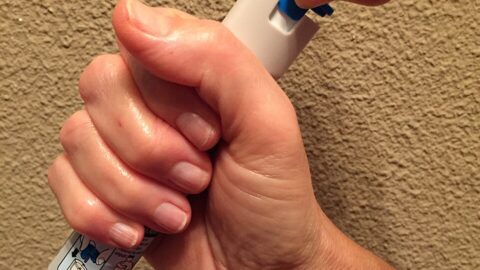 Hand holding an epinephrine autoinjector, the current standard of care for anaphylaxis