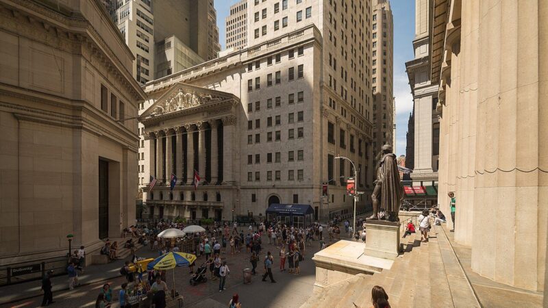 The New York Stock Exchange building viewed from Wall Street with crowds below