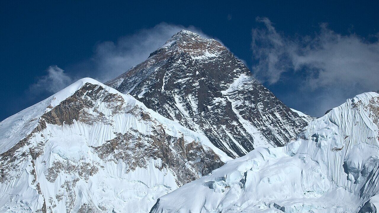 Snow-covered Mount Everest rising against a deep blue sky in the Himalayas