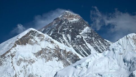 Snow-covered Mount Everest rising against a deep blue sky in the Himalayas