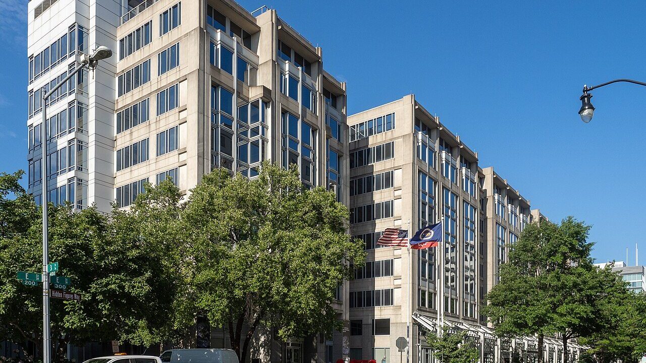 NASA headquarters building in Washington DC with flags and street trees in front