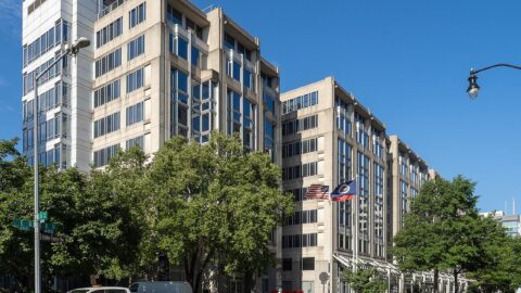 NASA headquarters building in Washington DC with flags and street trees in front