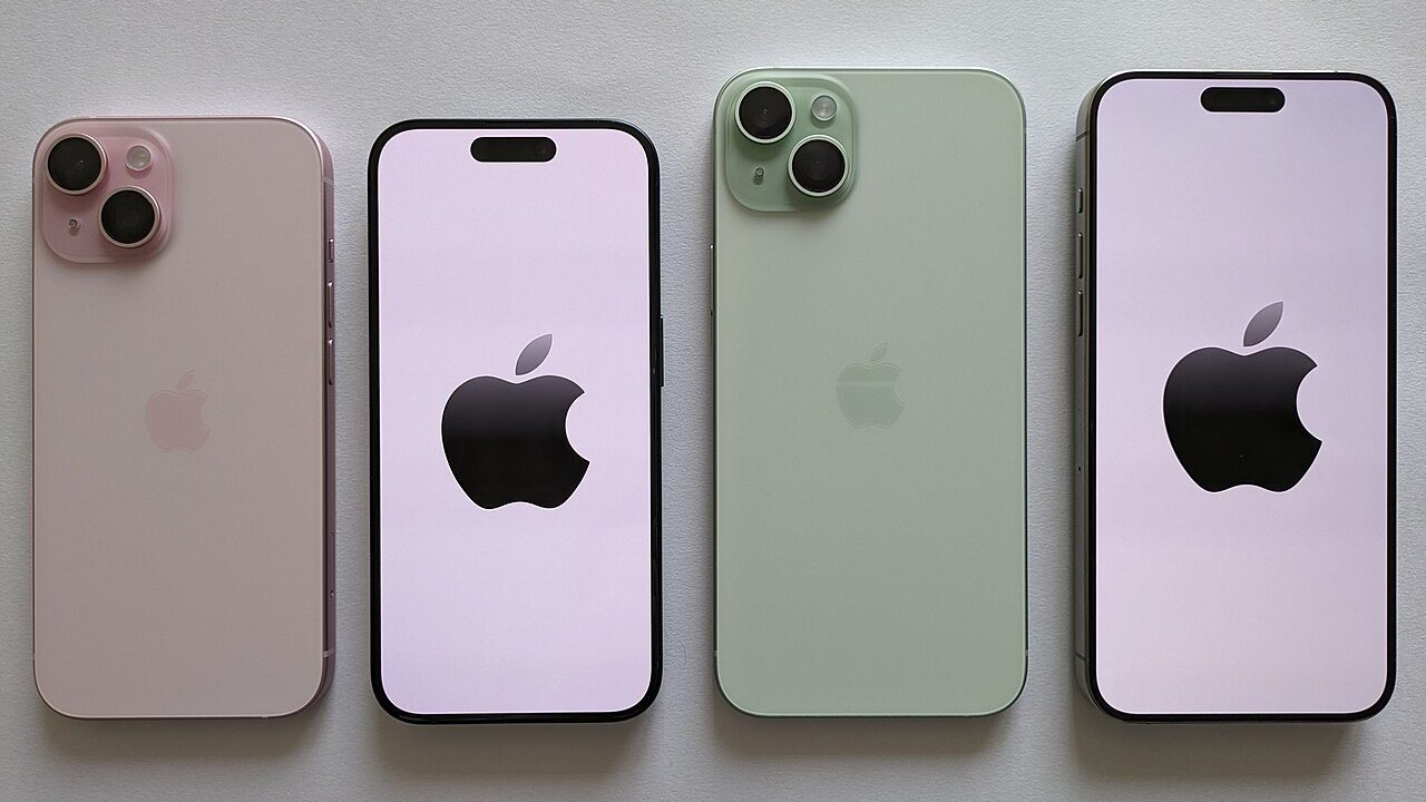Four iPhone smartphones in pastel colours arranged in a row on a light surface