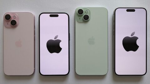 Four iPhone smartphones in pastel colours arranged in a row on a light surface