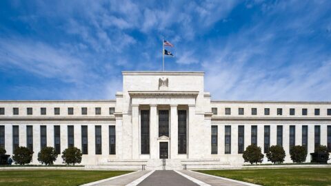 The Federal Reserve headquarters building in Washington DC under a blue sky