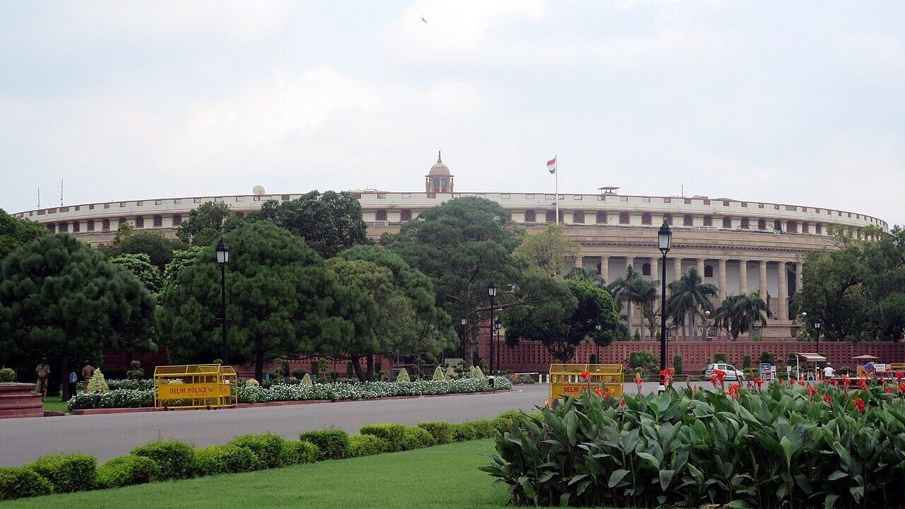 India's parliament building in New Delhi seen across gardens and a roadway