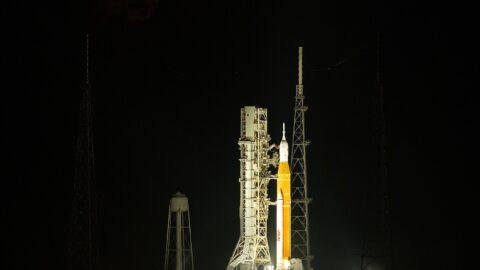 NASA SLS rocket on launch pad with moon rising above