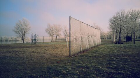empty youth soccer sports field with goal fence