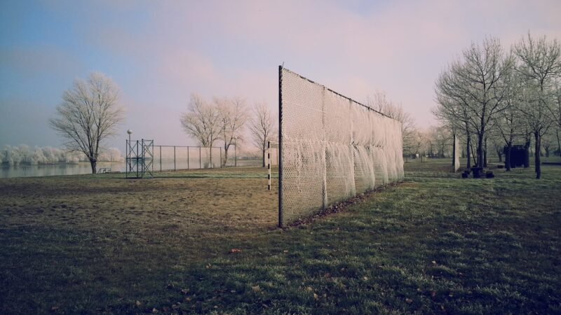 empty youth soccer sports field with goal fence