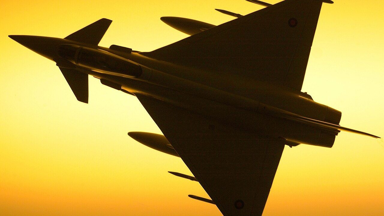 A Royal Air Force Typhoon fighter jet silhouetted against the sky
